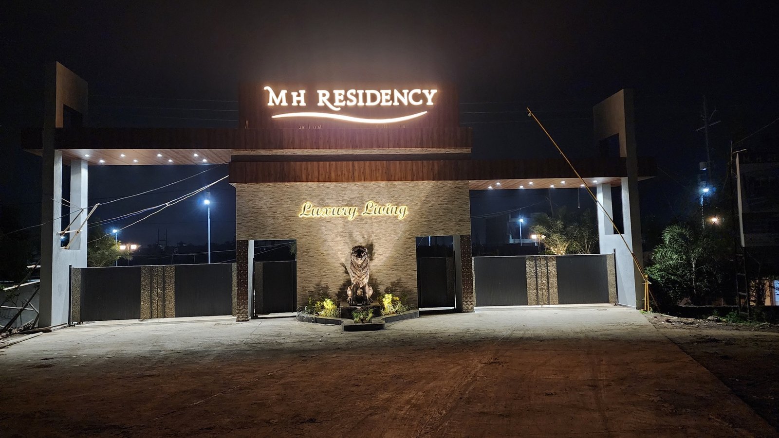 Actual night photograph of the illuminated MH Residency entrance gate